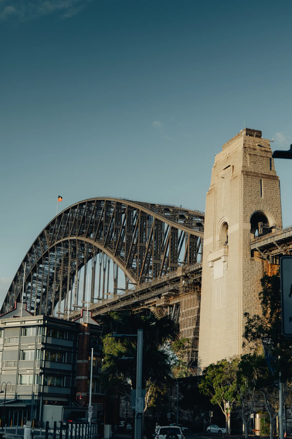 A granite pylon of the Harbour Bridge rising beside the arch
